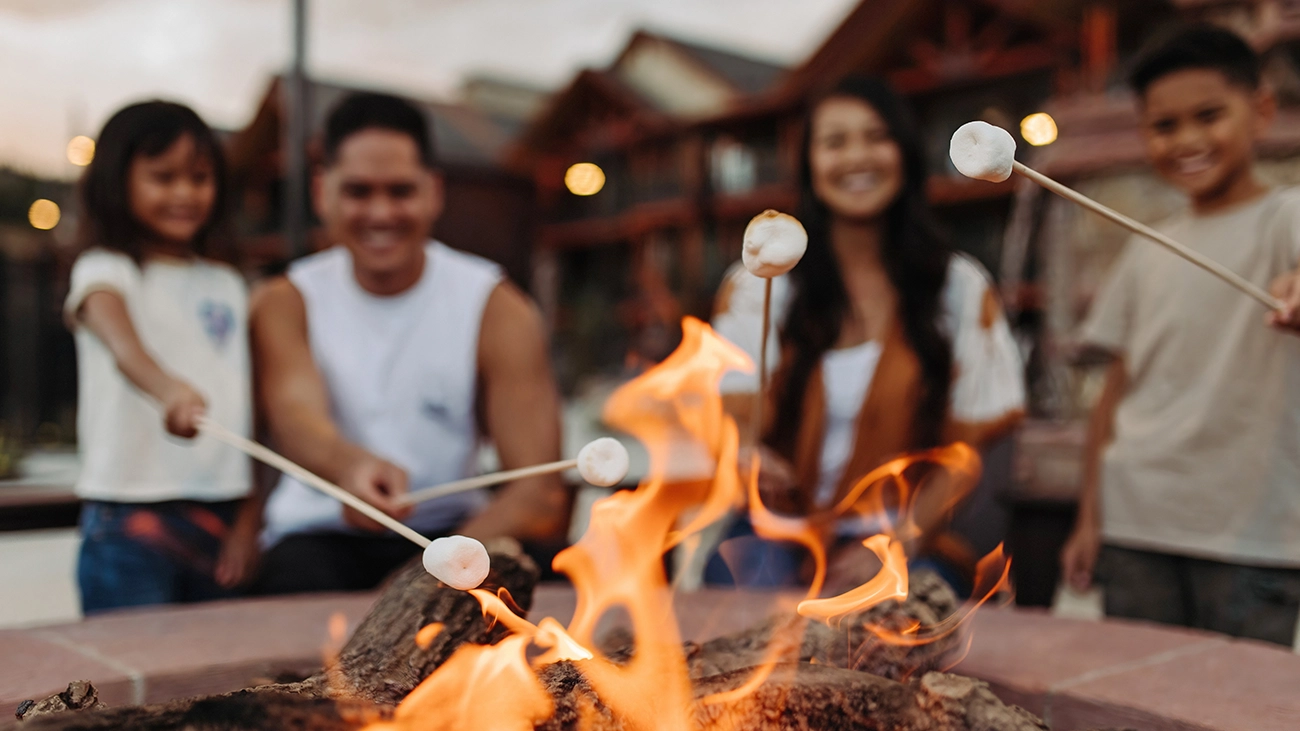 Family cooking smores around a fire pit