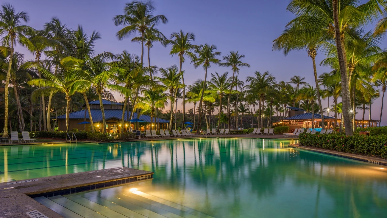 A junior Olympic-sized pool at dark with ambient lighting