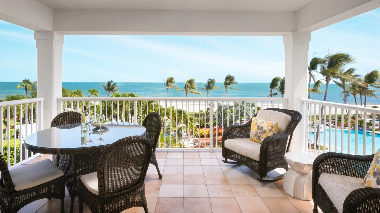 Outdoor dining gazebo with ocean and swaying palm trees in the background