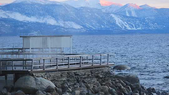 View of Lake Tahoe with rocky shores and snowy mountains