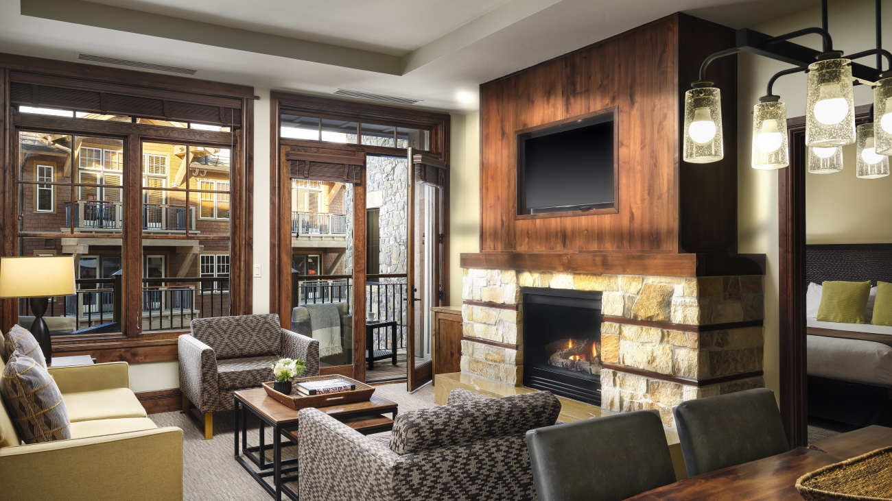 Spacious villa interior with working fireplace, sofa, armchairs, and dining table