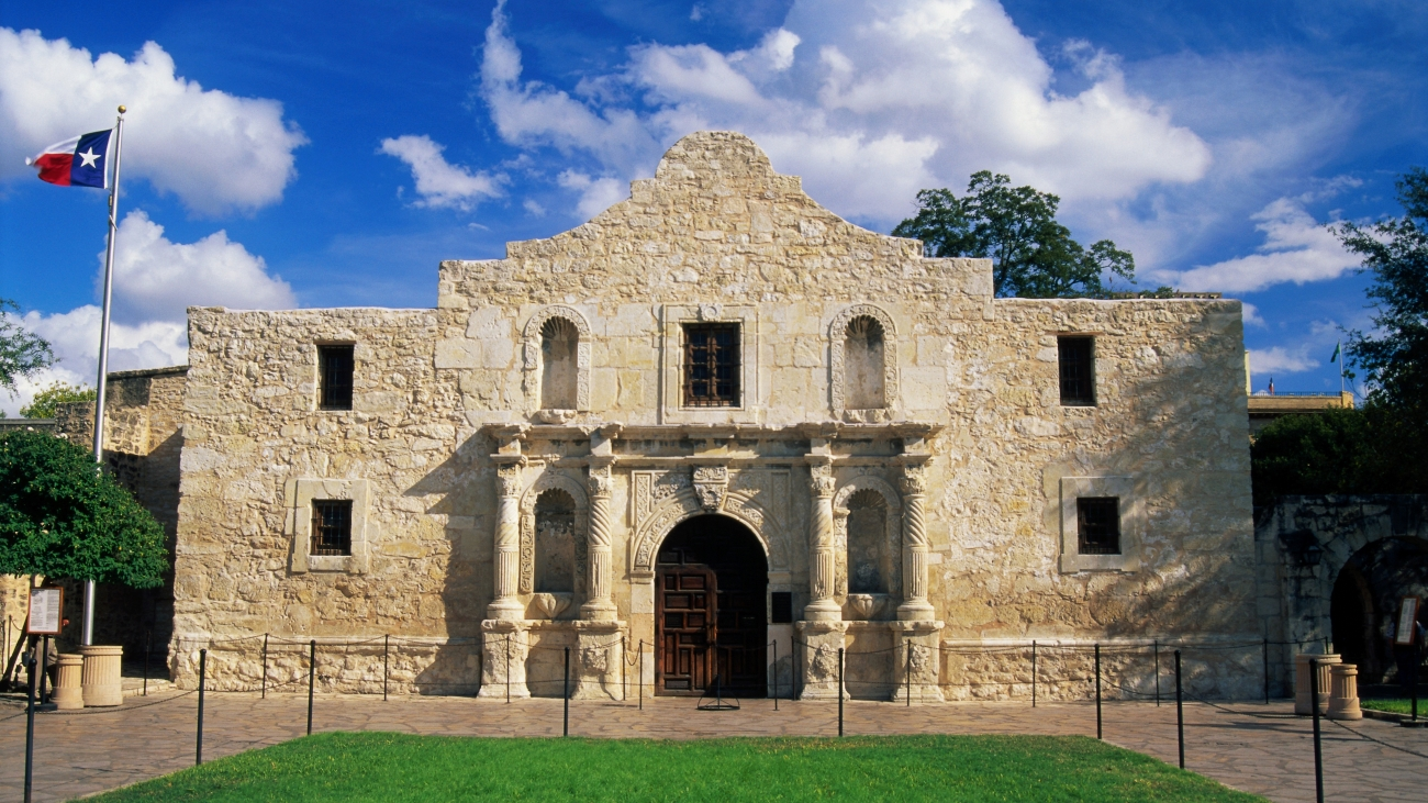 The Alamo and a flagpole with the Texas state flag