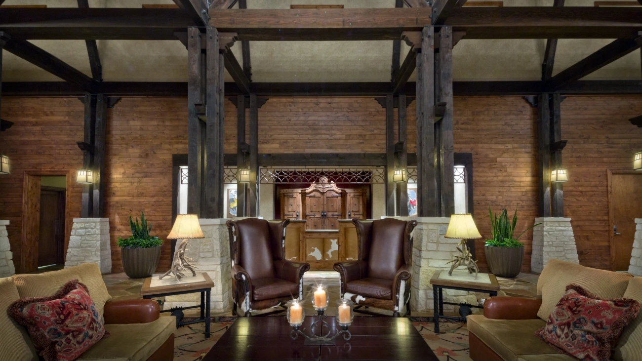 A cozy wood and stone lounge area with sofas, chairs, and coffee tables